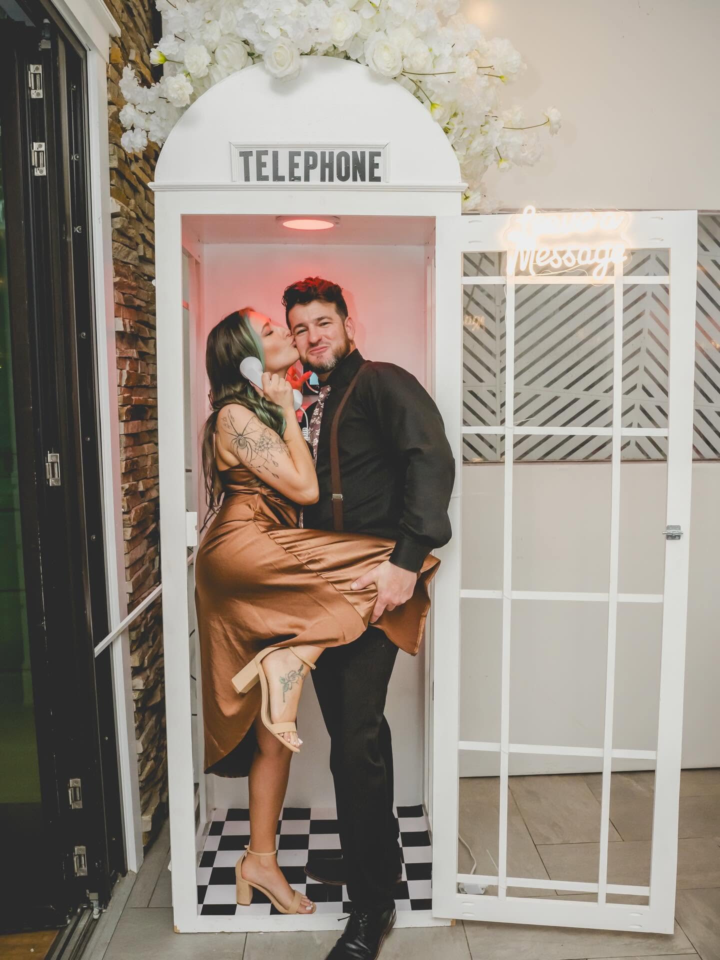 Couple using the white telephone audio guestbook at a celebration